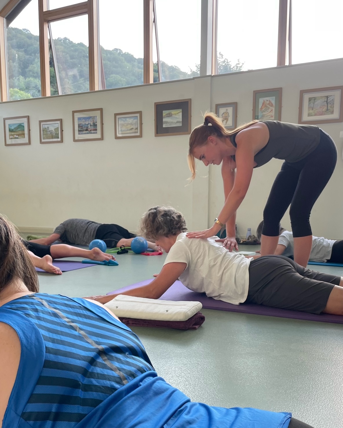Jess guiding a guest through a mindful stretch during a morning Pilates session